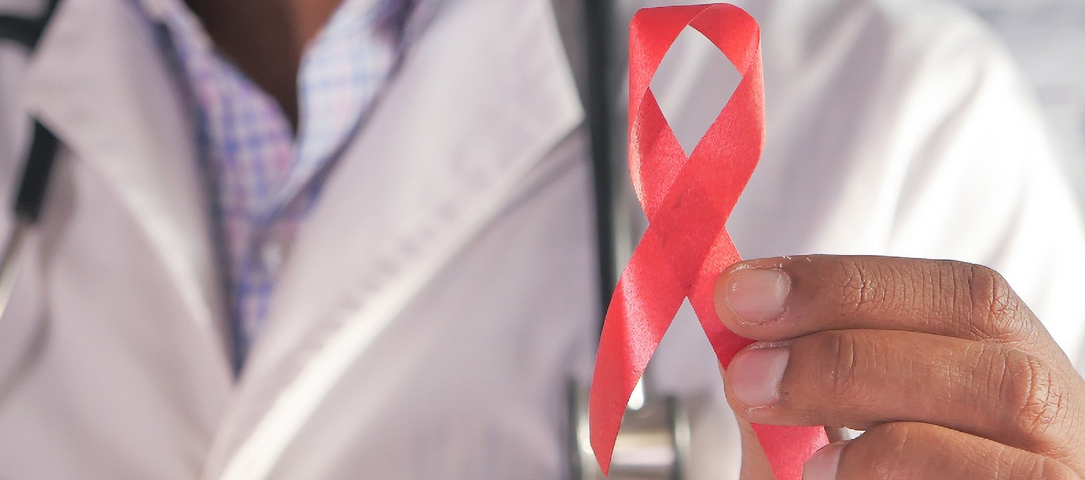 man in lab coat holding red ribbon