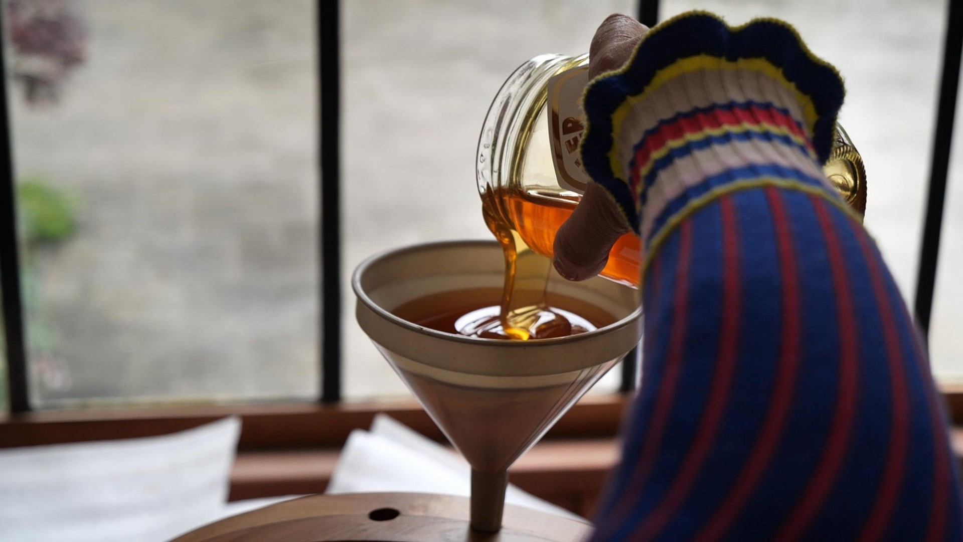 Pouring honey into a funnel