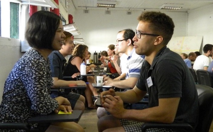 Students speaking across a desk