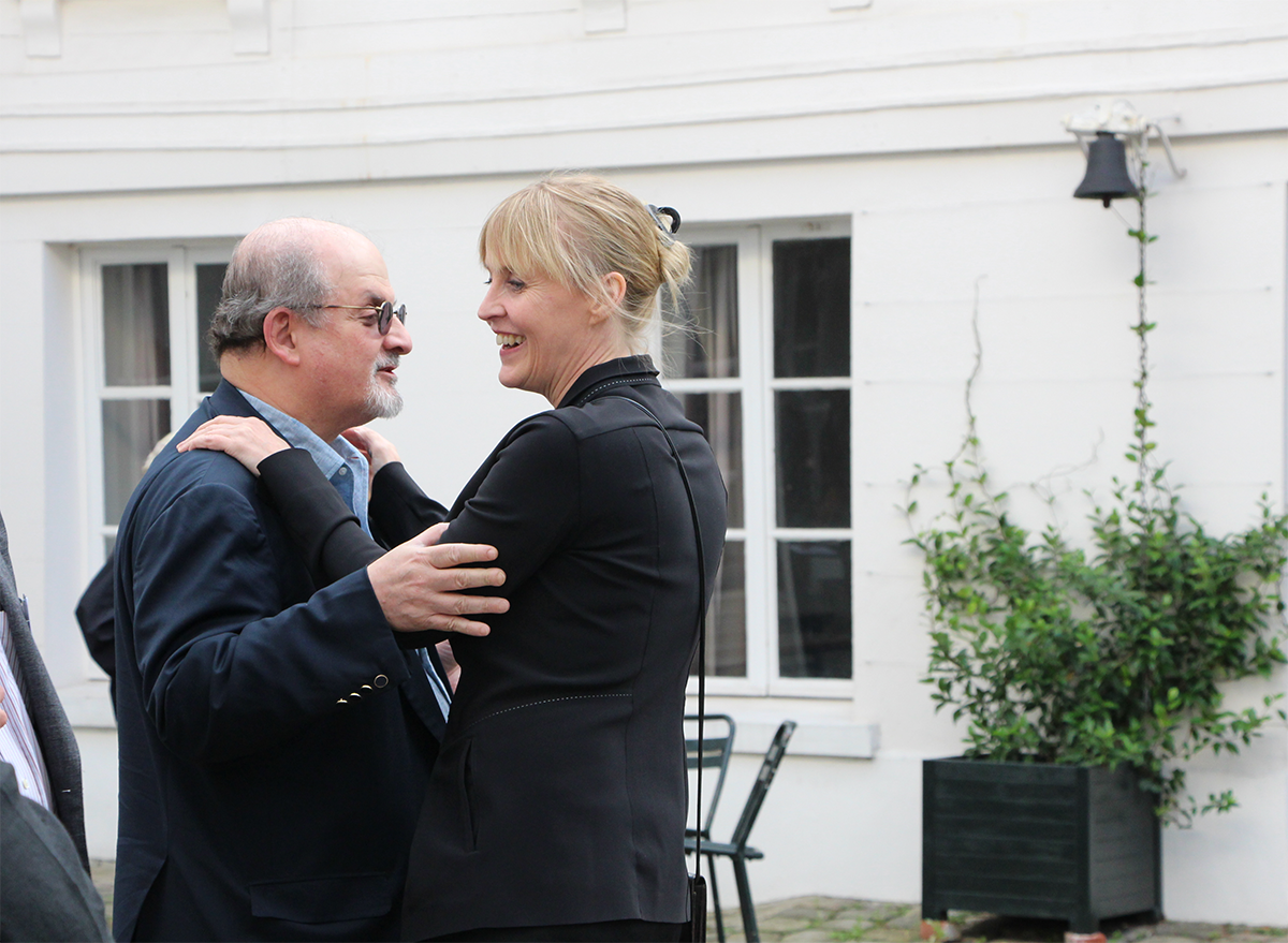 Author Salman Rushdie greets festival organizer Caro Llewellyn