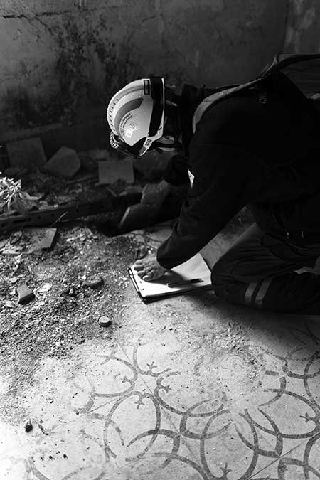 photo of worker on his hands and knees digging in floor