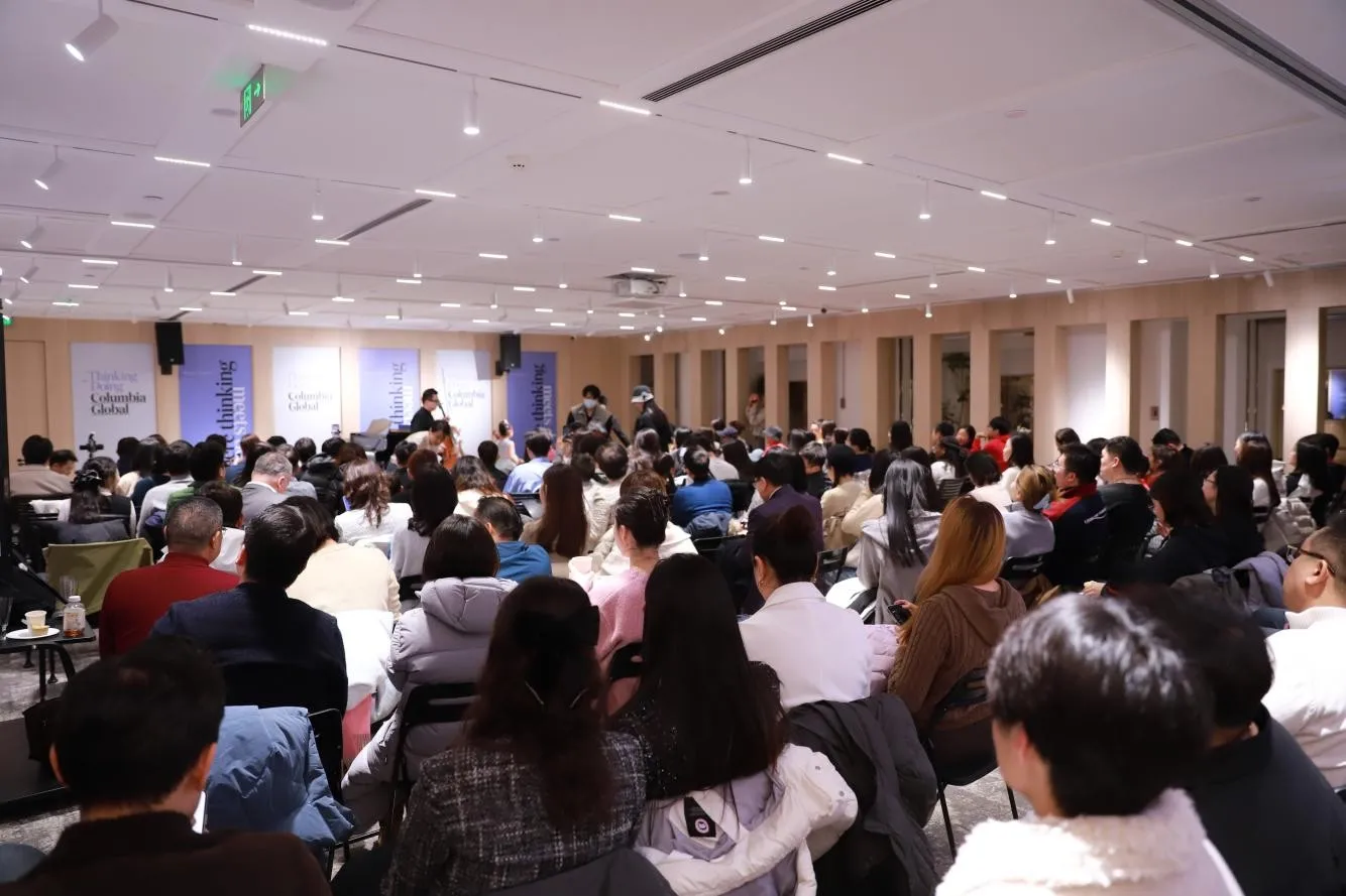 A crowded room of people sitting listening to a speaker at the new Beijing Center.