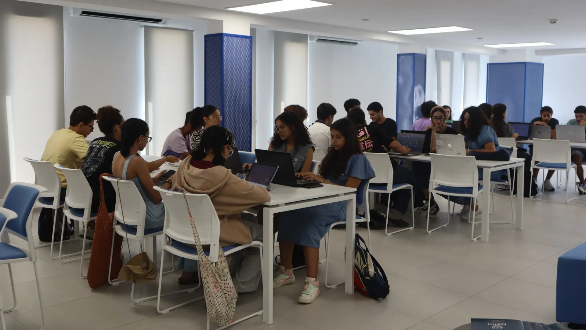 high school students sit at tables in a classroom