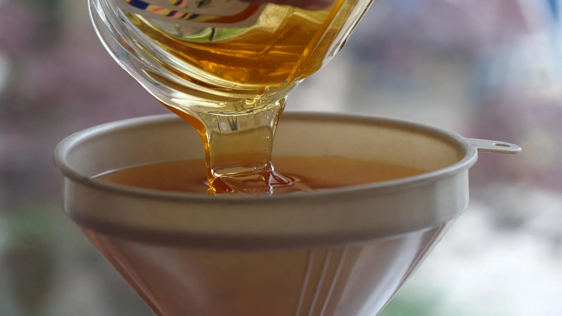 Pouring honey into a funnel