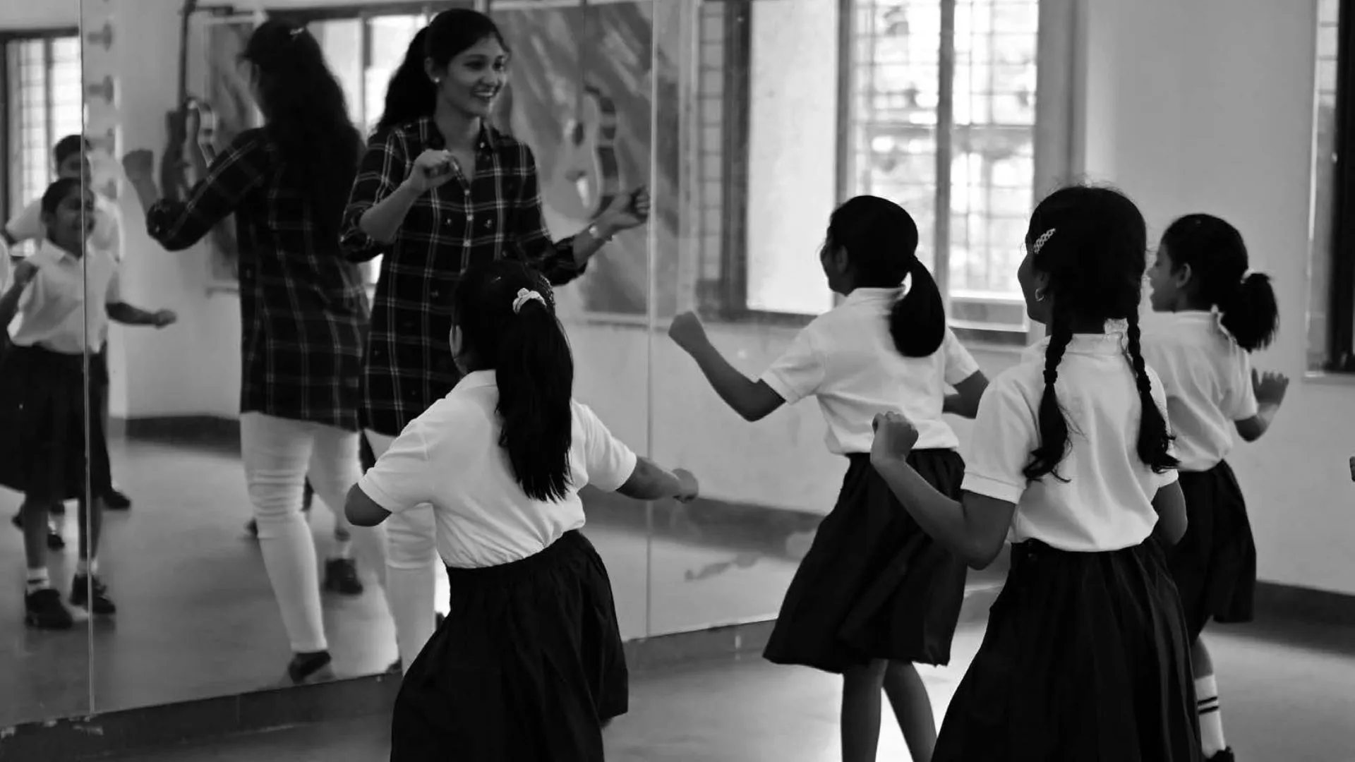 teacher teaching dance moves to students