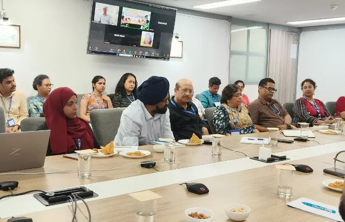 Audience sitting across a conference room listening to the speaker